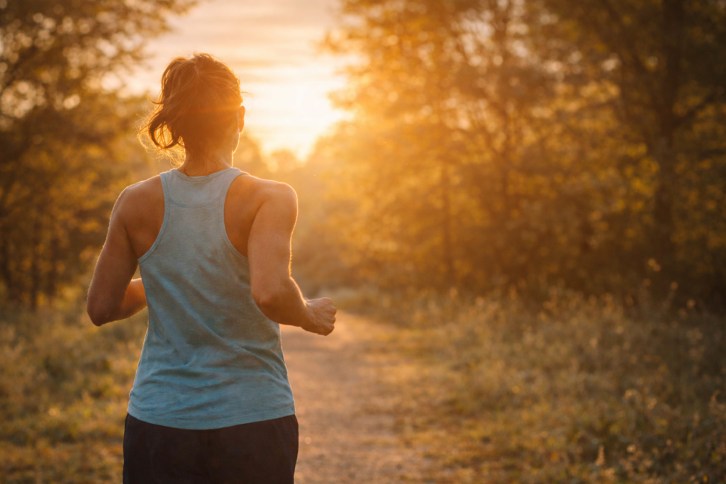 Woman running on sunlit pathway